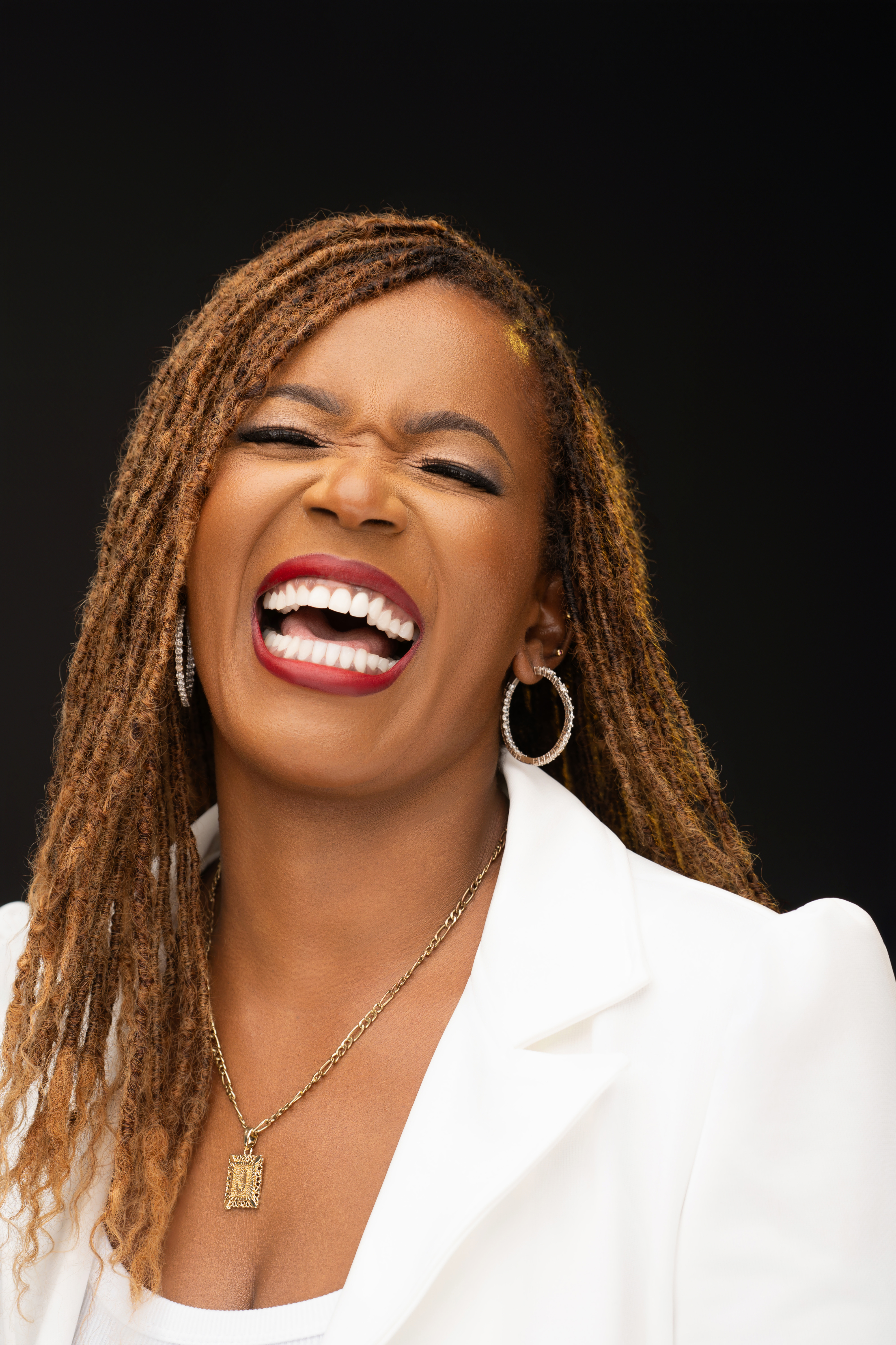 Joanne Marime laughing warmly in a white blazer